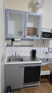 a small kitchen with a sink and a stove at Anwar House in London +239 photos