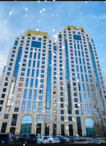 un grande edificio con auto parcheggiate di fronte di Esil Riverside Elite Apartments a Astana