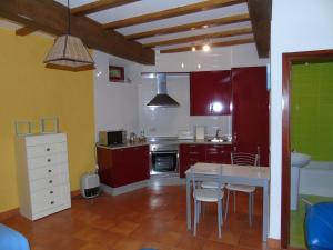a kitchen with red cabinets and a table and chairs at Loft O Viñal in Muros