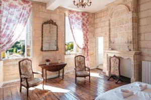 a bedroom with a bed and a table and chairs at logis-des-cordeliers in Saint-Émilion