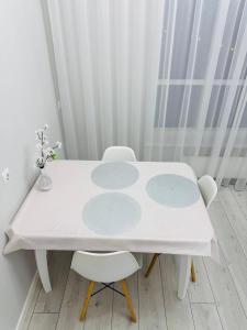 a white table and two chairs in a room at Esil Riverside Elite Apartments in Astana