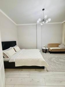 una camera da letto bianca con un letto e un divano di Esil Riverside Elite Apartments a Astana Altre 9 foto