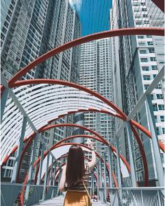 Una mujer parada debajo de un puente en una ciudad. en Oasis Landmark Apartment, en Ho Chi Minh 70 fotos más