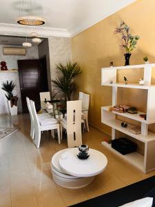 a living room with a table and white furniture at Blanca beach in Sidi Rahal
