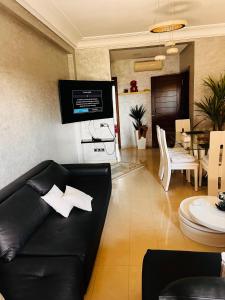 a living room with a black couch and a table at Blanca beach in Sidi Rahal