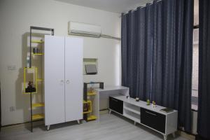 a room with a bed and a cabinet and a window at Karada Abu Nawas private room in Baghdad