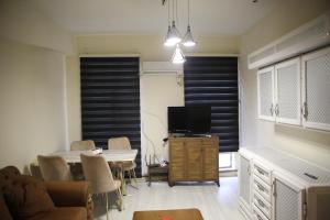 a living room with a dining table and a tv at Karada Abu Nawas private room in Baghdad +17 photos