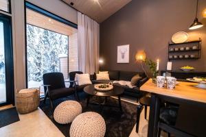 a living room with a couch and a table and chairs at Villa Havu A in Syöte