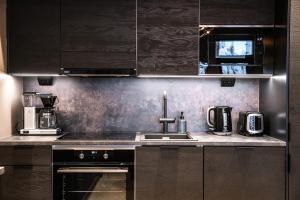 a kitchen with a sink and a stove top oven at Villa Havu A in Syöte +20 photos