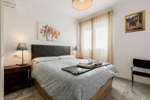 a bedroom with a bed and a table and a window at Apartamentos Sendero del Veleta in Cenes de la Vega