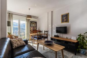 a living room with a couch and a tv and a table at Apartamentos Sendero del Veleta in Cenes de la Vega