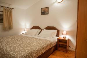a bedroom with a bed and two lamps on tables at Huter Apartments in Herceg-Novi