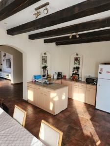 cocina grande con nevera blanca y armarios en Cabana Dealul Negru, en Dealu Negru