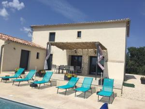 a group of blue chairs next to a building at Maison avec vue et sa piscine chauffée privative in Bessas