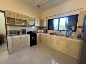 a kitchen with white cabinets and a large window at Hotel Caribe in Cozumel