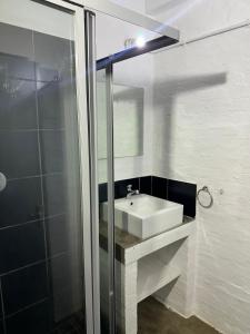 a bathroom with a white sink and a shower at The Hills by maboneng in Johannesburg