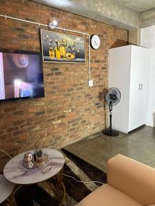 a living room with a brick wall and a table at The Hills by maboneng in Johannesburg