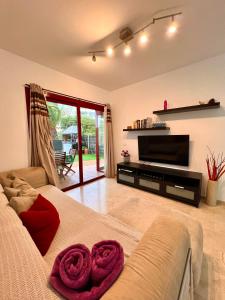 ein Wohnzimmer mit einem Bett und einem Fernseher in der Unterkunft Apartamento Balandros in Palm-mar