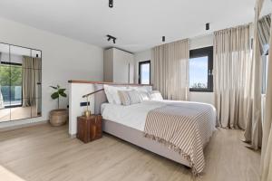 a white bedroom with a large bed and windows at Casa Calme luxury villa surounded with nature Opatija including EVcharging station in Opatija +21 photos