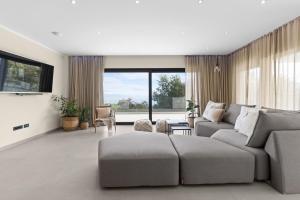 a living room with a couch and a table at Casa Calme luxury villa surounded with nature Opatija including EVcharging station in Opatija
