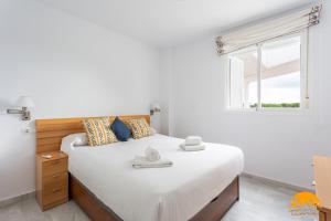 a bedroom with a large white bed with a window at Retama Golf by Cadiz Time in Novo Sancti Petri