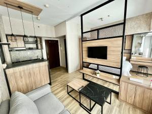 a living room with a couch and a tv at Nawasena Studio at Solo Paragon Apartment in Solo
