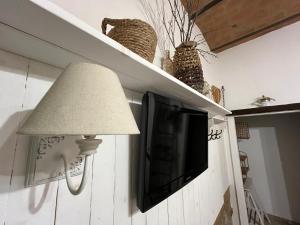 a flat screen tv on a wall with a lamp at Podere Montecorno in Alberese
