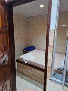 サルバドールにあるFlat na Praia em Salvador Térreoのベッドと鏡のある小さな部屋