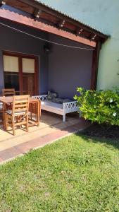 a patio with a table and a bed and a bench at refugioverdelobos in Lobos