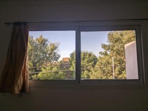 a window in a room with a view of trees at El Lapacho in Paraná +3 photos