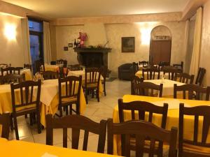 a restaurant with tables and chairs and a fireplace at Hotel ristorante Due Platani in Airuno
