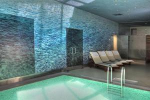 a room with a pool with chairs and a wall of water at Euphoria Club Hotel in Borovets