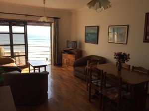 a living room with a couch and a table with a view at Casa da Praia in Vila Praia de Âncora