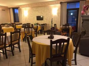 a restaurant with tables and chairs with yellow table cloth at Hotel ristorante Due Platani in Airuno