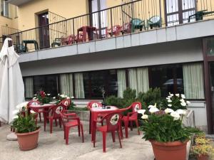 a group of red chairs and tables on a patio at Hotel ristorante Due Platani in Airuno