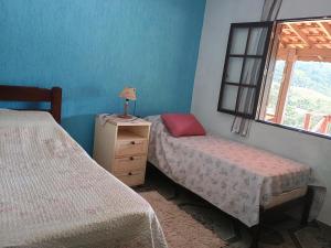 una camera da letto con due letti singoli e una finestra di Casa de Campo - Vista Exuberante São Bento do Sapucaí a São Bento do Sapucaí