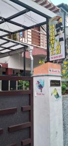 a building with signs on it with a fence at Hornbill inn in Cochin