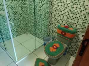 e bagno con servizi igienici e decorazioni verdi e arancioni. di Casa de Campo - Vista Exuberante São Bento do Sapucaí a São Bento do Sapucaí Altre 12 foto