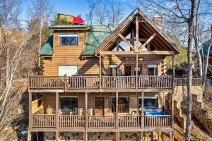 a log home with a wrap around deck at 8 Beds, Hot Tub, Fireplaces, Pool Tbl Arcade VIEWS! in Sevierville