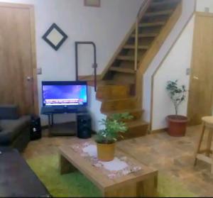 un soggiorno con TV, tavolo e scale di Patagone a Punta Arenas