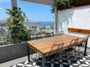 a wooden table and chairs on a balcony with a view at Monumental BR1 in Lima