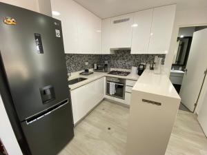 a kitchen with white cabinets and a black refrigerator at Monumental BR1 in Lima