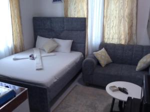 a small room with a bed and a couch at 3ts Homes studio unit-Bamburi in Mombasa +1 photo