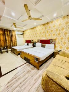a bedroom with two beds and a ceiling at Hotel Pak Continental Multan in Multan