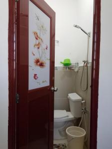 a bathroom with a toilet with a painting on the door at Subangan 2 in Burgos