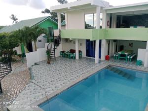 a house with a swimming pool in front of it at Apartment in Holidays Beach Resort in Bolinao