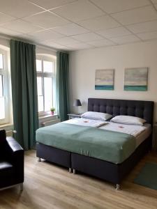 una camera da letto con un letto grande e una sedia di Maisonette Wohnung Schwaan a Schwaan