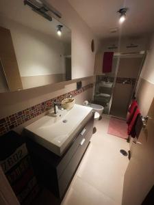 a bathroom with a sink and a toilet and a mirror at Testaccio Stay - your home in the heart of Rome in Rome