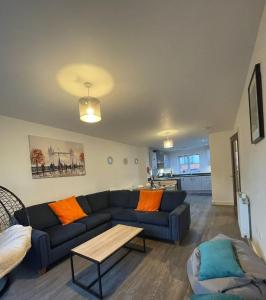 a living room with a couch and a table at Hawksbill 3 Bed Detached house with private parking in Peterborough