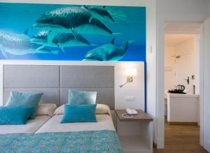 Schlafzimmer mit einem Bett mit einem Haibild in der Unterkunft Marvell Club Hotel & Apartments in Bucht von San Antonio